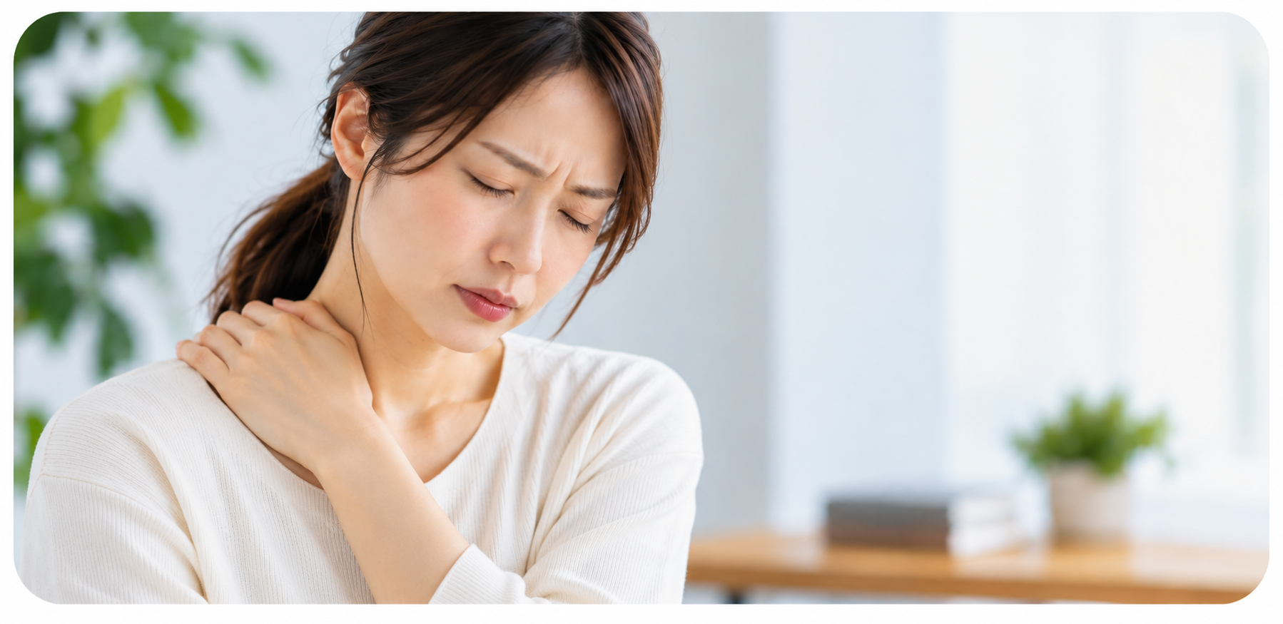 肩こりに悩み首から肩を押さえる女性